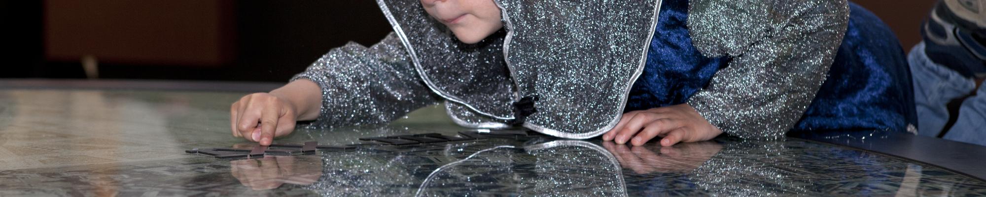 photo d'un enfant habillé en chevalier qui regarde un plan dans la Porte de Hal