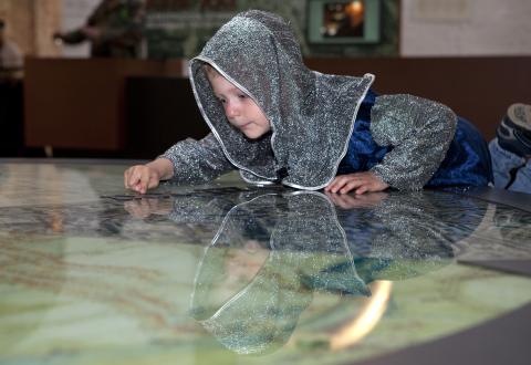 photo d'un enfant habillé en chevalier qui regarde un plan dans la Porte de Hal