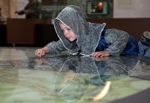 photo d'un enfant habillé en chevalier qui regarde une carte dans la Porte de Hal
